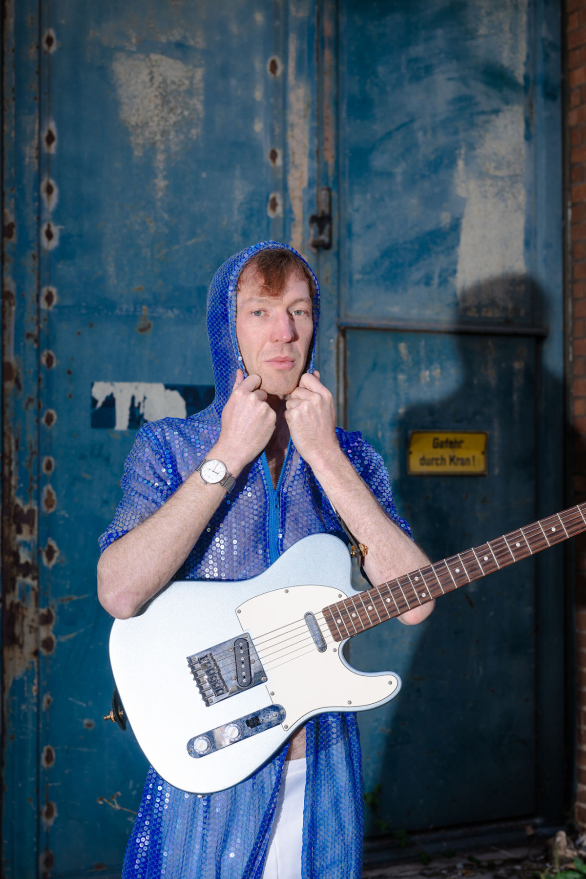 TCHAIR in blauem Glitzeranzug und blauer E-Gitarre