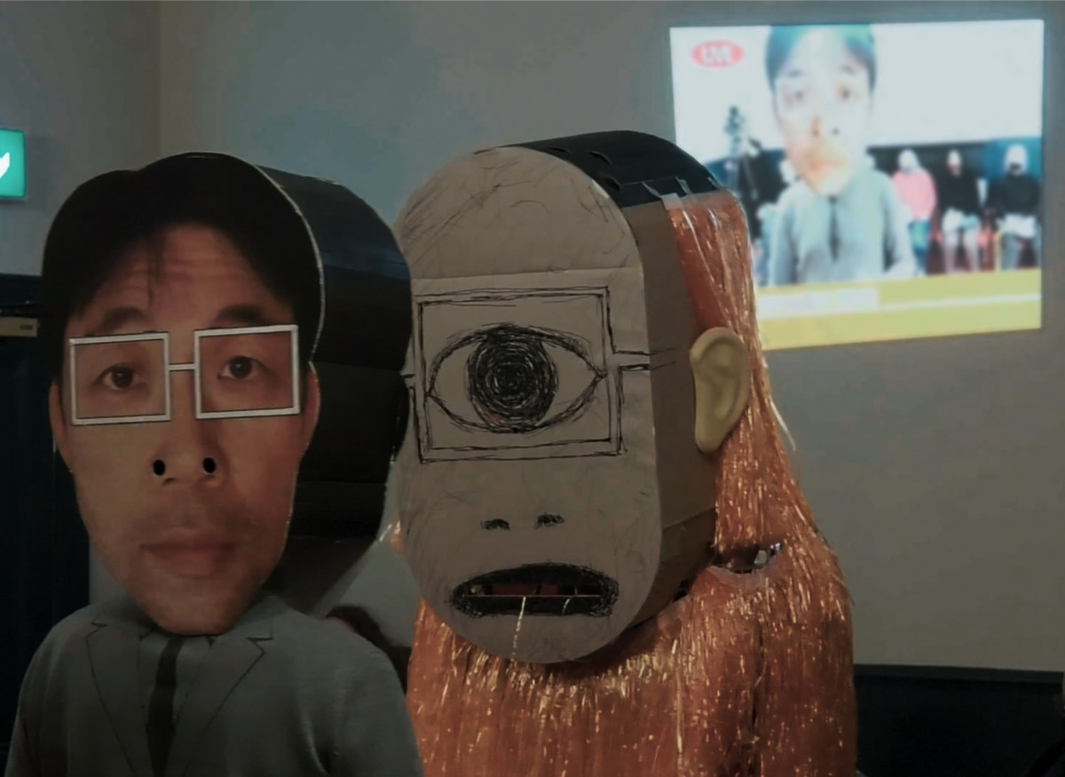 Ein Mensch mit Pappkopf und ein haariges, ein&auml;ugiges Monster