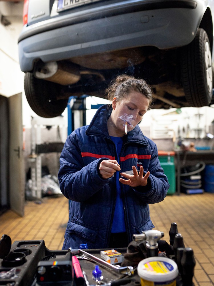 Verena Brakonier rauchend in einer Autowerkstatt