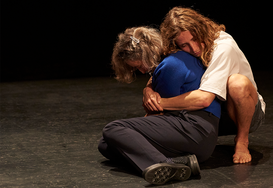 Eine Person umschlingt eine andere Person von hinten mit den Armen