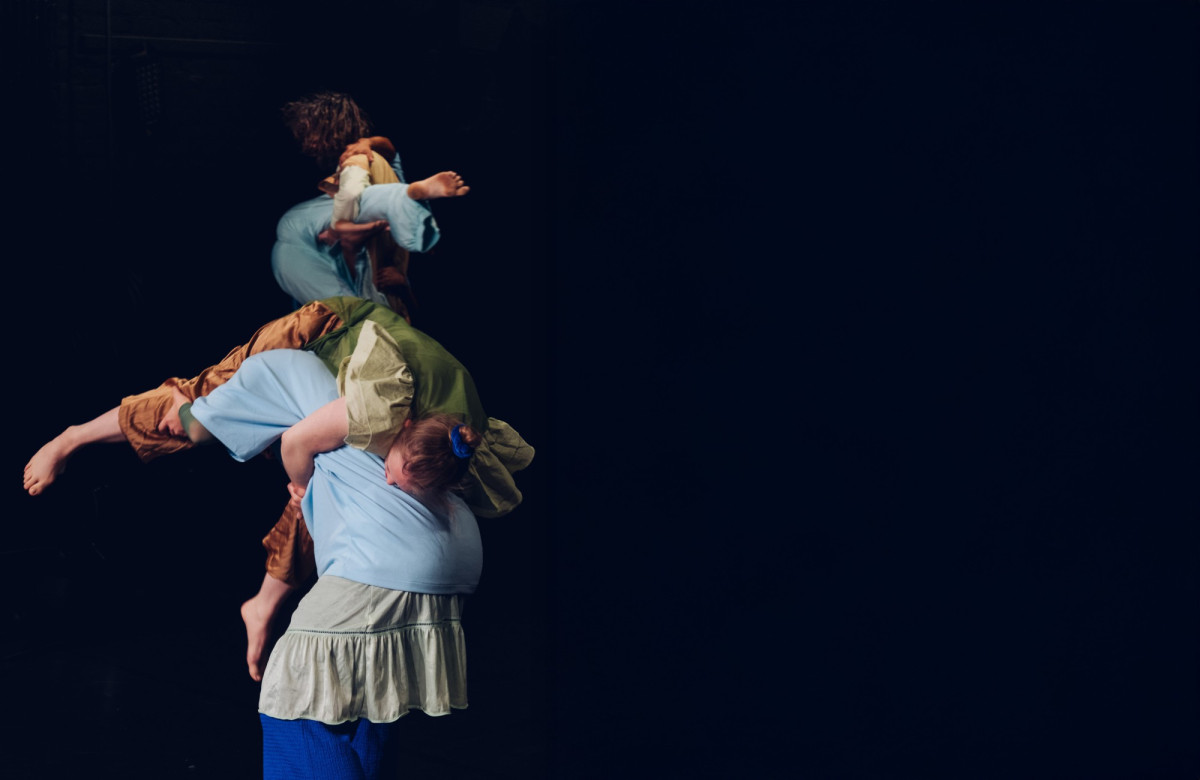 Drei T&auml;nzer*innen, wie eine Statue ineinander verschlungen