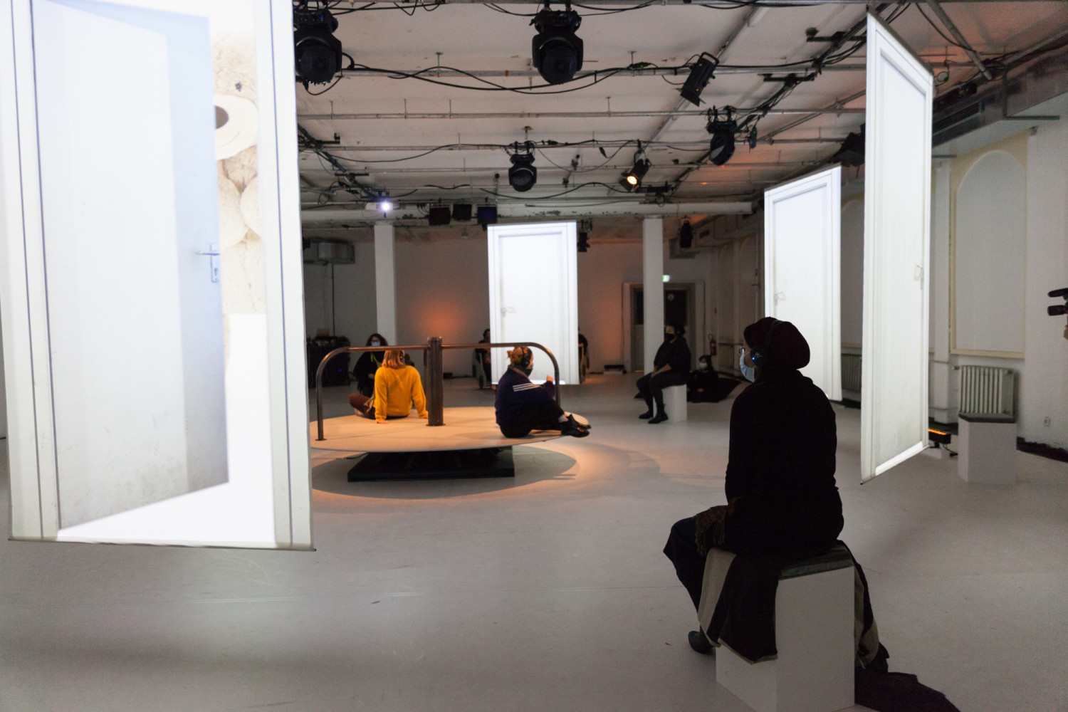 Eine Person mit Hijab betrachtet eine Videoleinwand