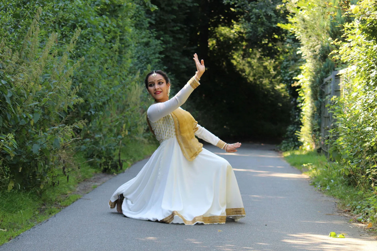 T&auml;nzer_in mit wei&szlig;em langen Gewand in Tanzposition