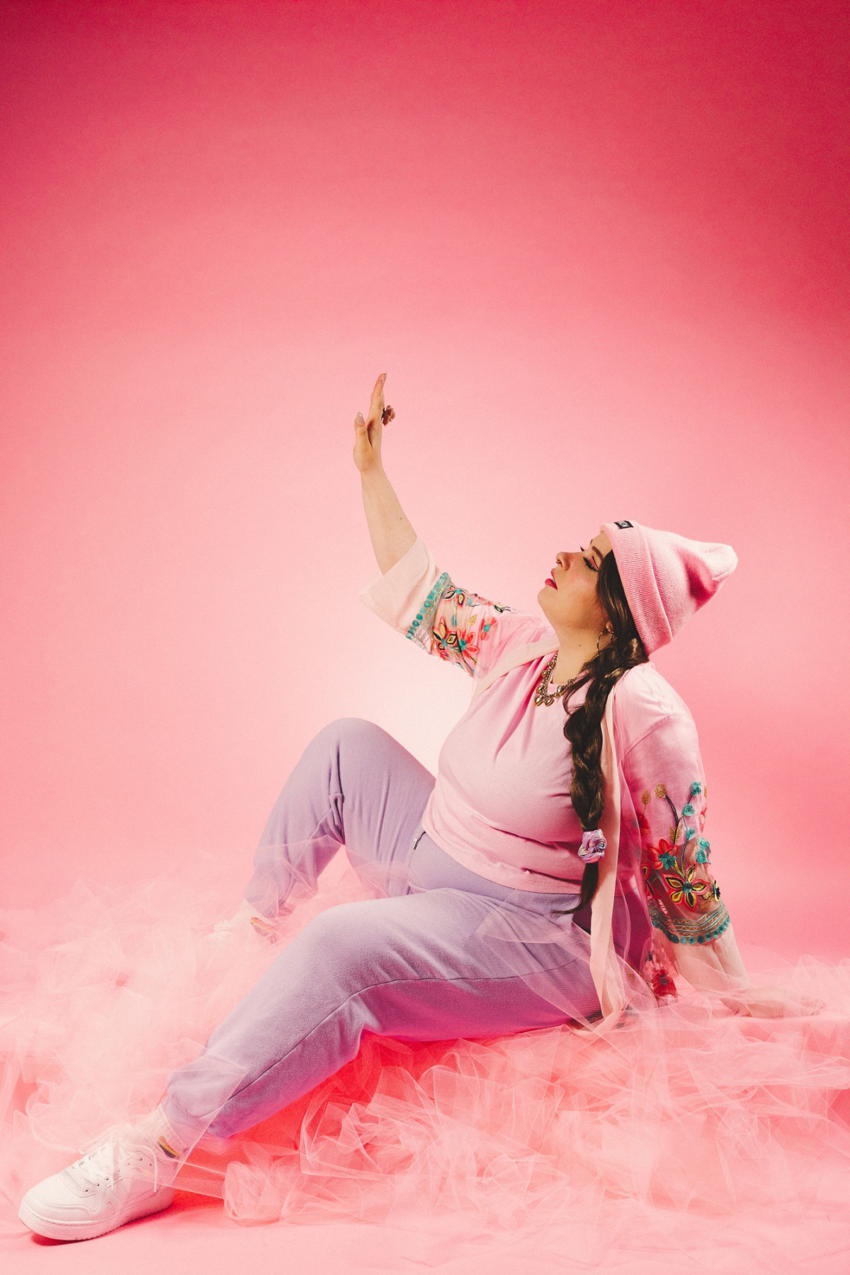 Finna posiert vor einem hellrosa Hintergrund