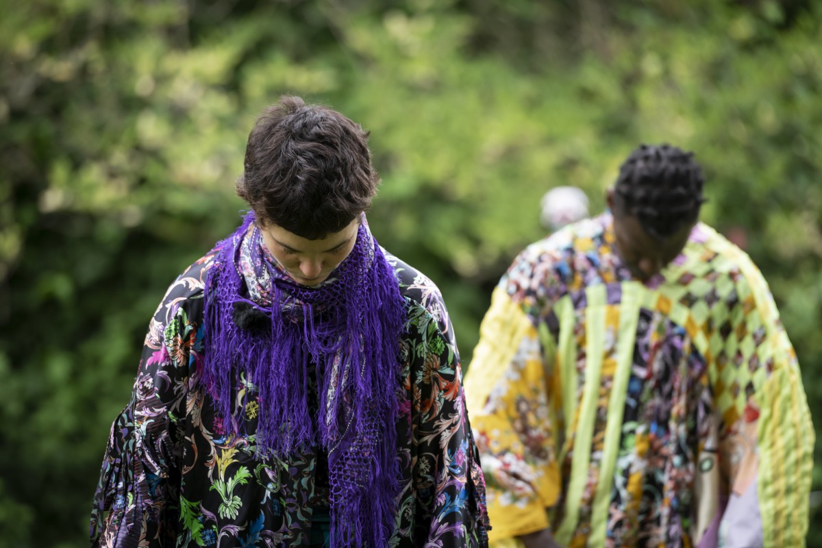 Two performers bow their heads